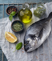 Dorado fish on the wooden  with lemon and rosemary. Top view.