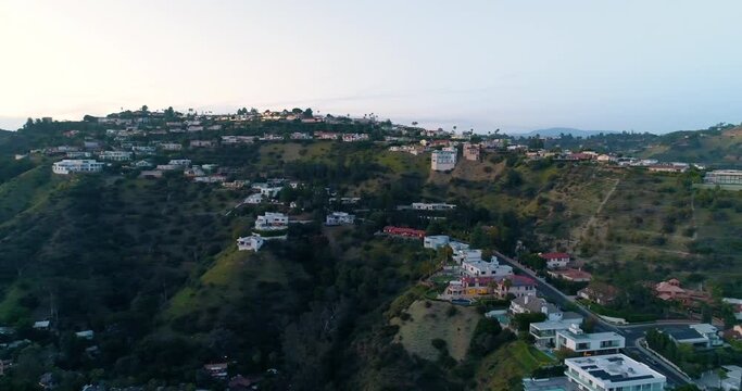 Aerial, pan, drone shot of houses of the Rich and Famous in The Hollywood hills, during dusk in Laurel Canyon, West Hollywood, Los Angeles, California, USA