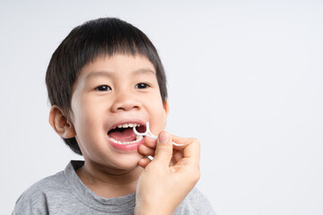 Asian boy about 4 years old is being cleaned teeth with dental floss