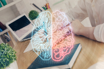 Multi exposure of writing hand on background with brain hologram. Concept of learning.