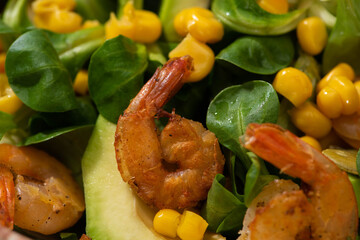 close up view of fresh green salad with corn, shrimps and avocado