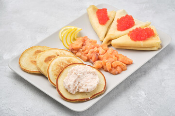 Russian pancakes with salmon and red caviar