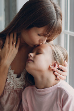 Mother hug and kiss with a little daughter. Close up portrait,