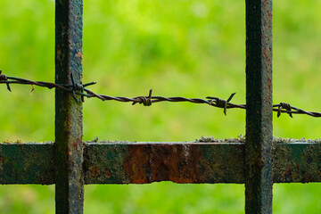 Close up of old rusty fence with barbed wire