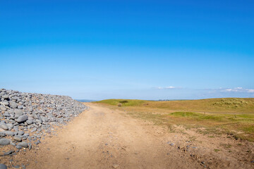 Path across Northam Burrows reserve and SSSI, with grass, sand and pebbles. Scenic north Devon, UK.