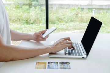 Young man people who hold credit cards and smartphones for online shopping and making payments Internet