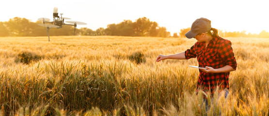 A woman farmer examines the field of cereals and sends data to the cloud from the tablet. Smart...