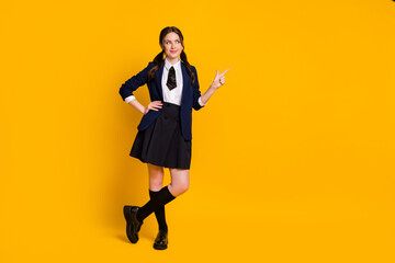 Full length body size view of her she nice attractive pretty cheery schoolgirl demonstrating indicate index product copy space advert ad isolated on bright vivid shine vibrant yellow color background