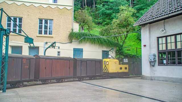 Yellow locomotive and wagons enter in Peca mine. Slovenia