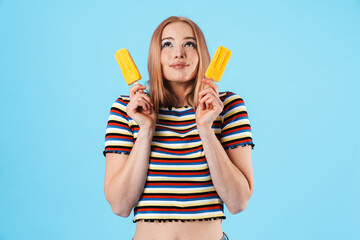 Image of pleased pretty girl holding ice-cream and looking upward