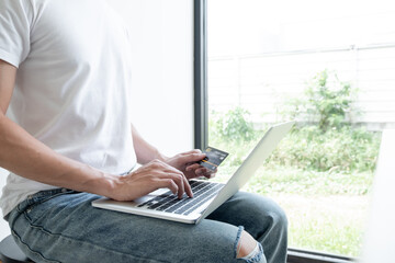 Naklejka premium Young man people who hold credit cards and use laptops for online shopping and making payments Internet