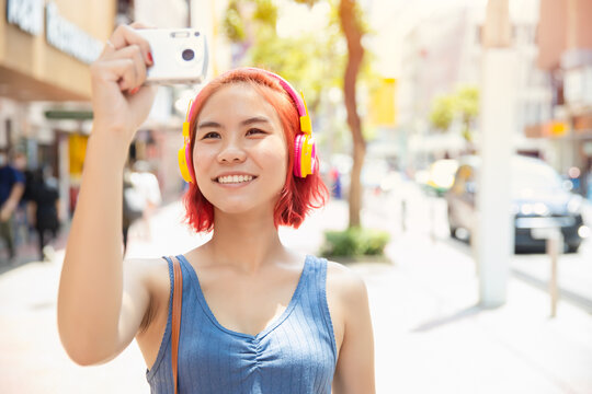 Asian girl teen happy smile to travel with camera take a photo around the city outdoor summer season