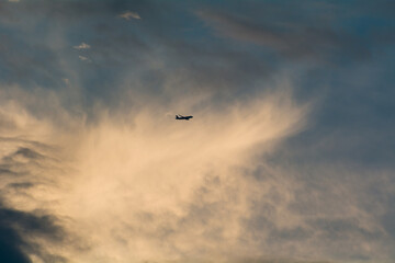 silhouette of commercial airliner flying through the sky.