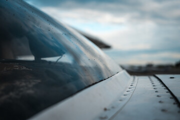 Rain drops on the windshield of small general aviation airplane.