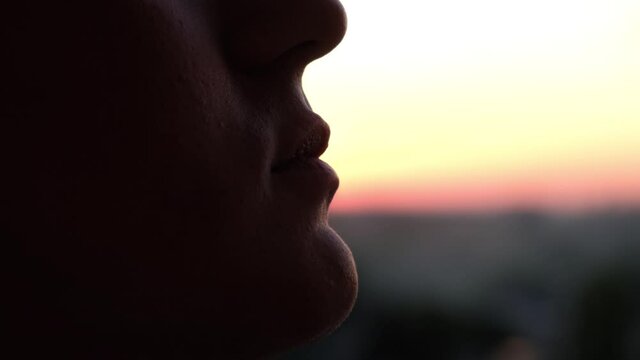 Silhouette of a man eating the sun as a joke on a sunset background