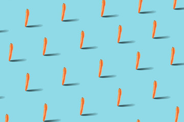 Trendy carrot isometric pattern on bright blue background. Creative and modern food minimal concept.