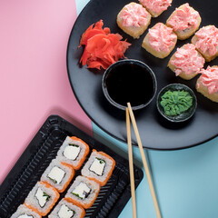 Top view on the plate of rolls with pink cream and Philadelphia roll