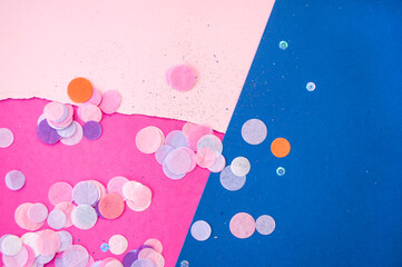 Colorful confetti, sparkles on bright pink, pastel and classic blue background. Festive background.