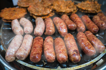 Frying sausages on a grill on a chinese market stall