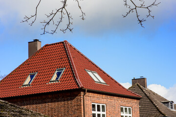 Haus mit rotem Backstein und rotem Walmdach