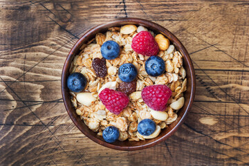 Healthy breakfast. Fresh granola, muesli with yogurt and berries on wooden background. Copy space.