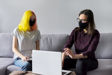 Teacher working with college student, in black protective masks