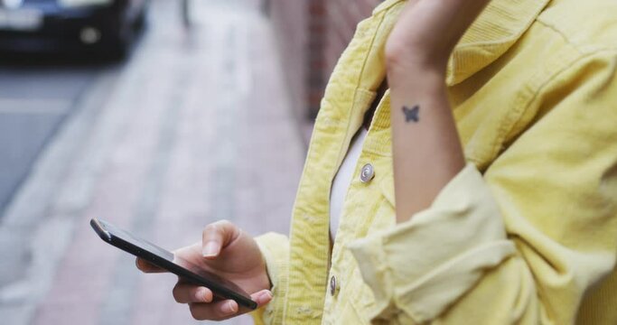 Mixed race woman using smartphone on the street