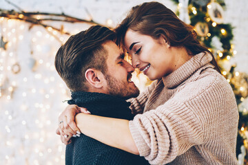 Happy caucasian couple in love having fun together near beautiful Christmas tree 