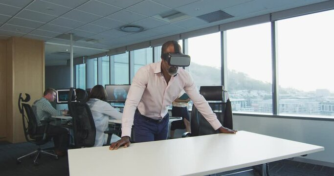 African American businessman wearing VR headset in modern office