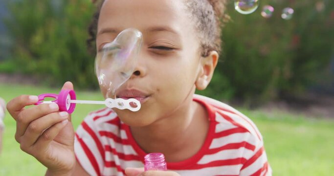 African american girl doing bubbles outside