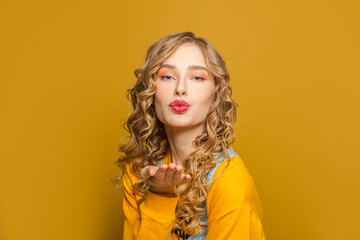 Lovely woman in yellow sweatshirt on bright background