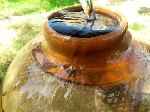 Filling Water In A Clay Pot Overflowing In Summer During Lack Of Water In Rural Areas