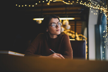Female teenager preparing for exams while studying with books