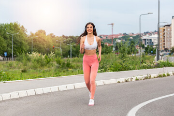 Young woman runner running on asphalt road , female in sport clothes jogging on the street, Healthy lifestyle concept