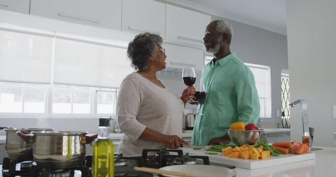 A senior African american couple enjoying a glass of wine in social distancing