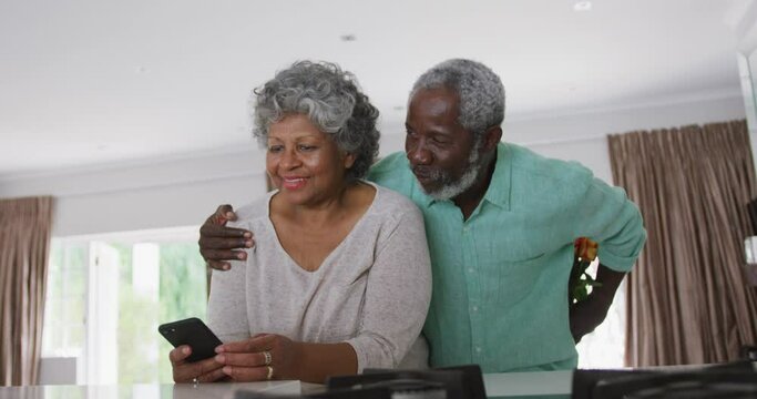 A senior african american man offering flowers to his wife. social distancing in quarantine.