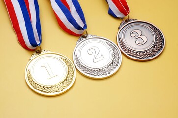 Gold medal, silver medal and bronze medal on yellow background, concept for winning or success