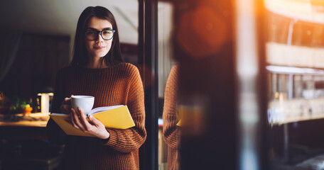 Female teenager reading book and drinking coffee