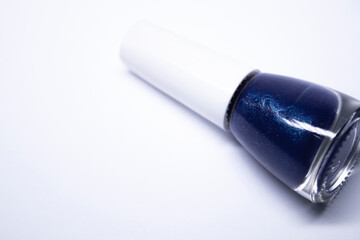 A bottle with blue nail polish on white background. nail lacquer. Nail manicure concept. Isolated, copy space. 