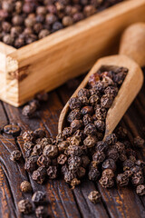 aromatic black pepper on a dark wooden rustic background