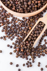 fragrant black pepper on white acrylic background