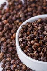 fragrant black pepper on white acrylic background