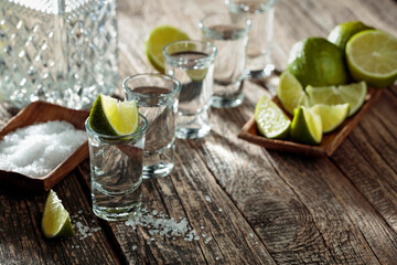 Tequila with  salt and lime on a old wooden background.