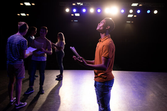 Side view of students practicing in a theater