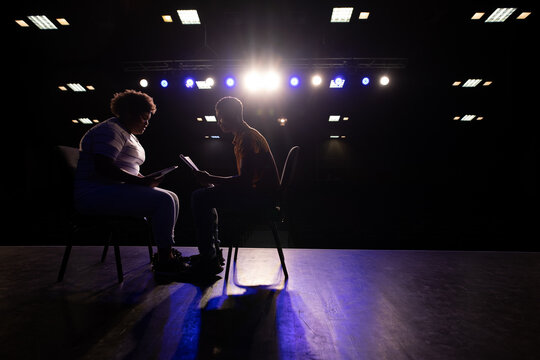Side view of students practicing in a theater