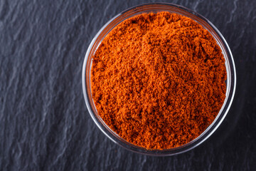 aromatic spicy chilli powder on a dark stone background