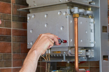 disassemble the gas boiler,hand unscrews the bolt on the gas boiler, boiler repair