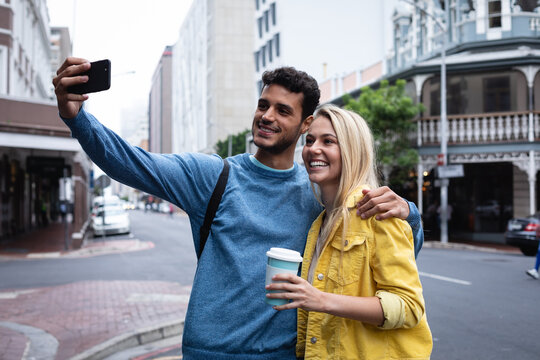 Caucasian couple on the go in the city taking selfie