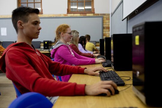 Side view of students working on computers