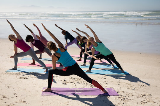 Yoga teacher taking yoga session on beach